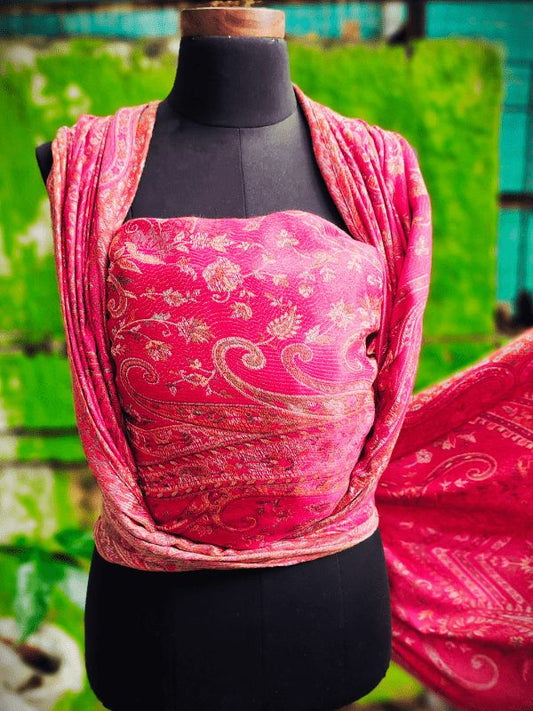 Rose gold cashmere baby wrap displayed on a mannequin in a snug front carry, showing detailed woven patterns and smooth drape. This ergonomic newborn wrap sling offers even weight distribution, breathable comfort, and a secure fit for hands-free parenting, designed for all caregivers.