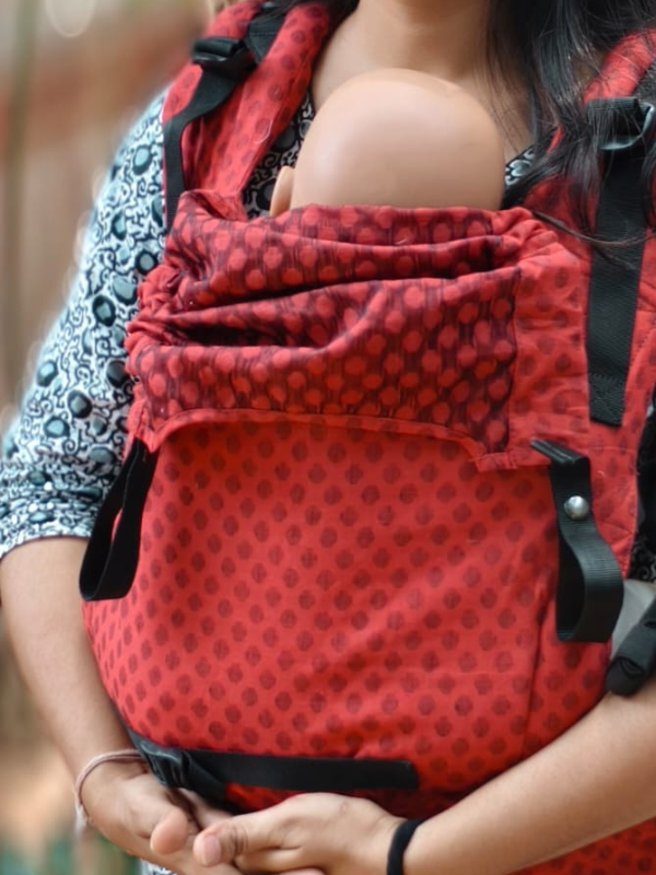 Almitra Tattva Mangalmay Sunrise ergonomic baby carrier front carry with newborn positioned high on caregiver’s chest, adjustable waist belt and padded panel for breathable, hands-free parenting and everyday babywearing comfort.