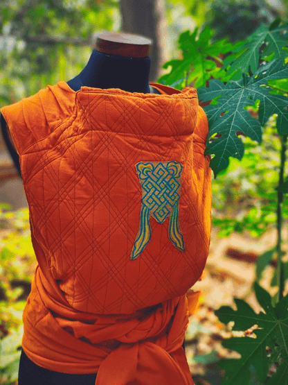 Rear view of Agni Meh Dai baby carrier featuring ergonomic back panel, soft pleated shoulder straps, and traditional Indian motif embroidery.