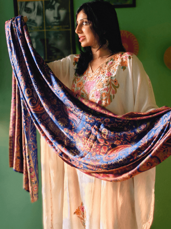 Caregiver indoors holding falak woven baby wrap sling stretched wide to display full fabric width, featuring intricate soft drape, and lightweight construction for ergonomic babywearing.