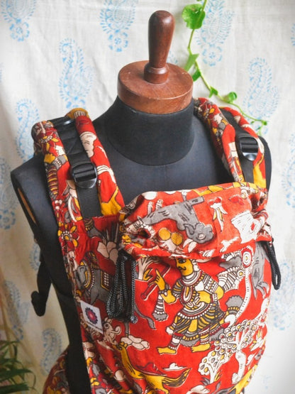 Jataka Tales Baby Carrier Statement SSC baby carrier in bold red Kalamkari print, adjustable ergonomic baby carrier with structured panel and hood, crafted for inclusive caregivers seeking breathable newborn carrier and modern hands-free parenting.