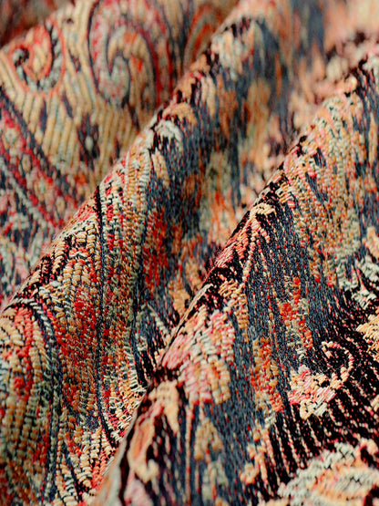 Macro image of Kalindi cashmere blend baby wrap displaying soft undulating folds, rich black and clay tones, and breathable woven texture suited for comfortable newborn babywearing and extended carries.