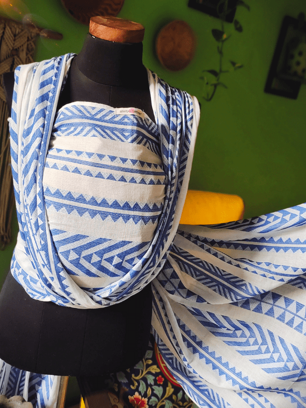 Almitra Tattva Neelanjana woven wrap displayed on mannequin, showing geometric tribal patterns in blue and white cotton blend fabric.
