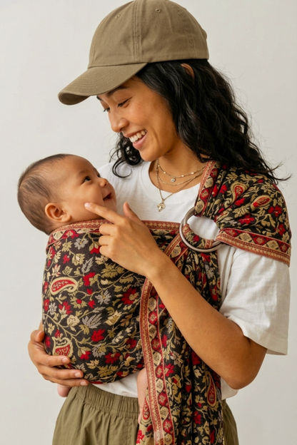 Side profile of a sleeping baby resting against their mother's chest inside a soft Chenab 2.0 ring sling with silver aluminum rings.